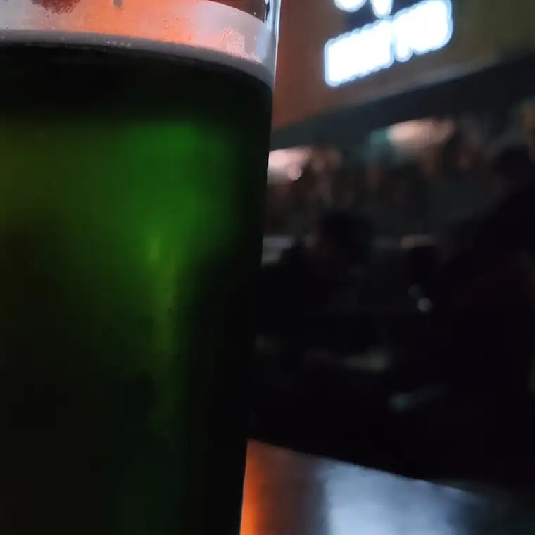 Zielony drink w szklance na barze w półmroku